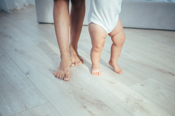 The bare feet of the child and mother are on the floor