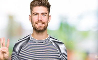 Young handsome man wearing stripes sweater showing and pointing up with fingers number four while smiling confident and happy.