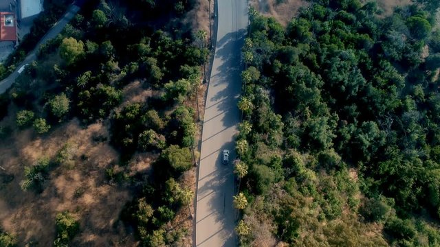Drone gimbal reveal of car driving towards downtown Los Angeles - 4k UHD