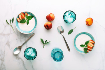 Fototapeta na wymiar Top view of healthy breakfast of natural greek yoghurt, nectarines and water on marble table. Flat lay.