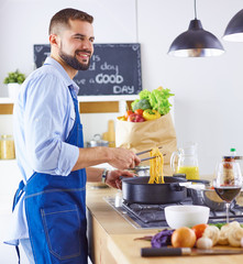 Smiling and confident chef standing in large kitchen