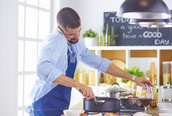 cooking, profession and people concept - male chef cook with smartphone at restaurant kitchen