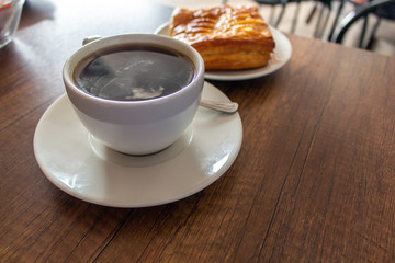 coffee cup served on a table next to a pineapple cake