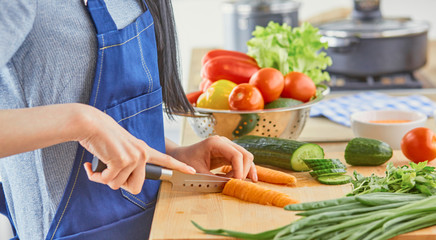 A young woman prepares food in the kitchen. Healthy food - vegetable salad. Diet. The concept of diet. Healthy lifestyle. Cook at home. Cook