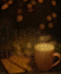 Fototapeta na wymiar pink cup of hot drink, when behind a window is rain / cozy home atmosphere