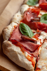 Macro close up of roman square pizza on a thick dough with mozzarella, pastrami, sweet plum and...