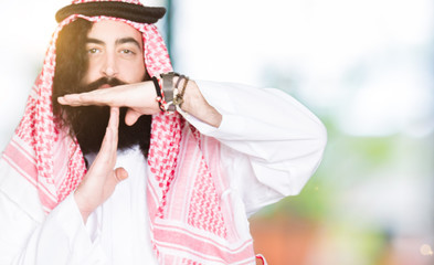 Arabian business man with long hair wearing traditional keffiyeh scarf Doing time out gesture with...