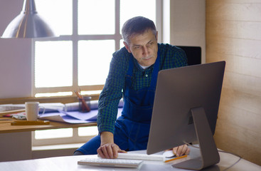 Engineer carpenter working on laptop and sketching project