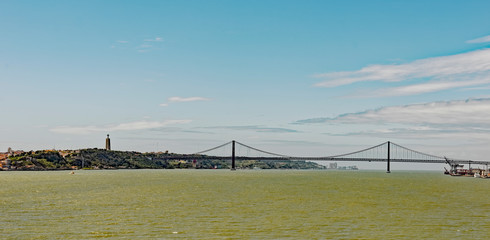 View from the River Tagus at Lisbon, Portugal of the 25 de April suspension bridge and the Christ...