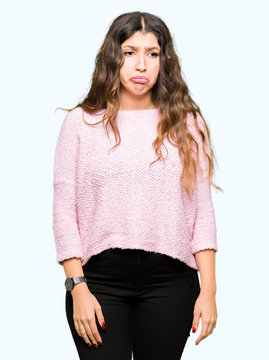 Young beautiful woman wearing pink sweater depressed and worry for distress, crying angry and afraid. Sad expression.