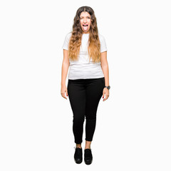 Young beautiful woman wearing casual white t-shirt sticking tongue out happy with funny expression. Emotion concept.