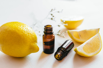 Two bottle of lemon essential oil on white background for beauty, skin care, wellness and medicinal purposes.