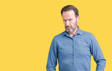 Handsome middle age elegant senior man over isolated background skeptic and nervous, frowning upset...