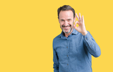 Handsome middle age elegant senior man over isolated background smiling positive doing ok sign with hand and fingers. Successful expression.
