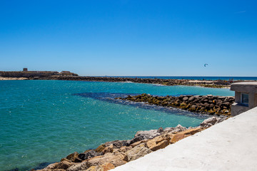 Obraz premium View from Tarifa, Andalusia Spain to Isla de las Palomas with stone breakwaters