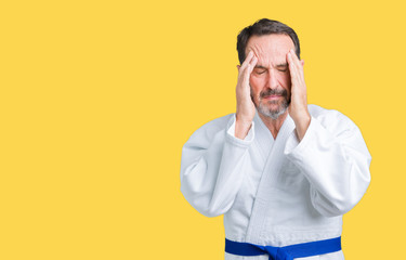 Handsome middle age senior man wearing kimono uniform over isolated background with hand on head for pain in head because stress. Suffering migraine.