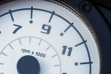 White tachometer display with black numbers from 7 to 11. Close-up