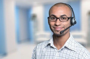 Portrait of a smiling man with headset working as a call center operator