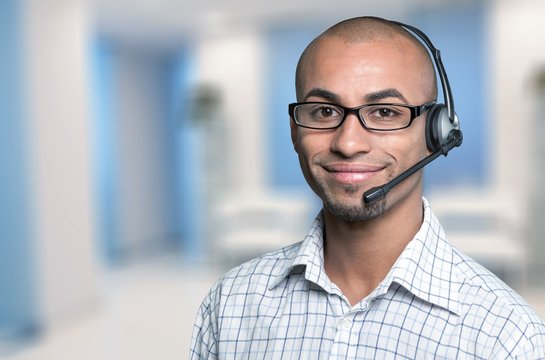 Portrait Of A Smiling Man With Headset Working As A Call Center Operator