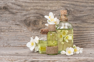 Obraz na płótnie Canvas Jasmine massage oil fresh flowers wooden background