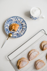 Delicious homemade dessert on blue plates. Shortbread sweet with coffee in a white mug. teaspoon golden. Saucer with earrings of leaves. On a white background.