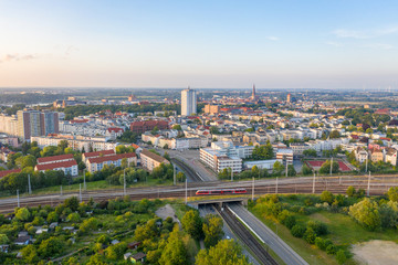 Fototapeta premium aerial view of the city of rostock, railway tracks, river warnow and power plant chimney in the background