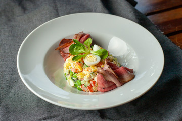 Fancy salad with thai style marbled beef with greens, crunchy cucumber, bell pepper and green peas