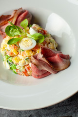 Close up of luxurious salad with thai style marbled beef with greens, crunchy cucumber, bell pepper and green peas