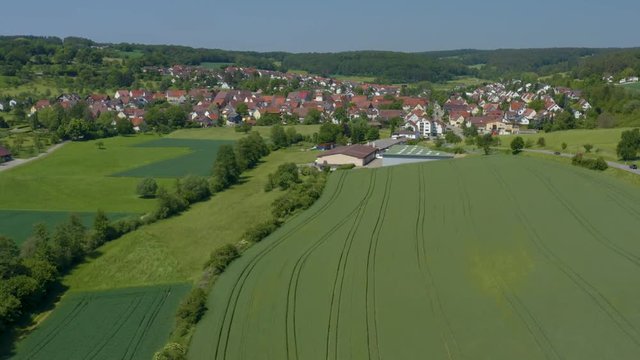 Aerial of Ostelsheim, Germany.  Camera zooms in and rotates right, tilting down as it passes over the town.