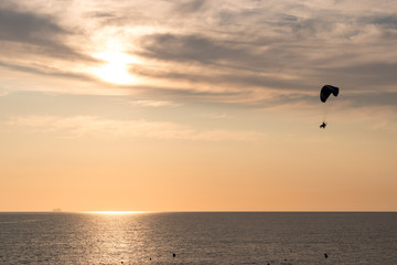 A powered parachute over the bay of Cadiz over the Mediterranean sea during sunset