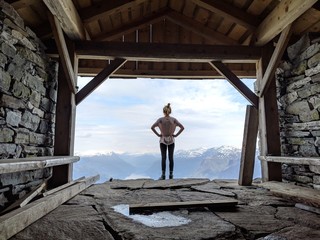 Woman looking over mountains through a shelter