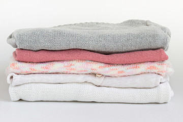 A stack of  woolen, cashmere  sweaters on table.