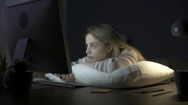 Sleepy woman leaning on a pillow on the desk