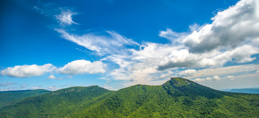 Panoramic photo of puffy clouds move over the mountains along the Blue Ridge Parkway in North Carolina, USA.