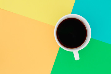 Coffee black in cup on a difference brightly colored background. Top view.