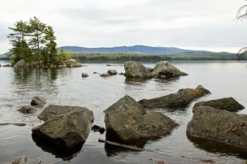 The rocky shoreline of a Maine lake.  - 274336966