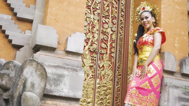 Pretty balinese dancer with traditional costume standing and posing in the temple. Shot in 4k resolution