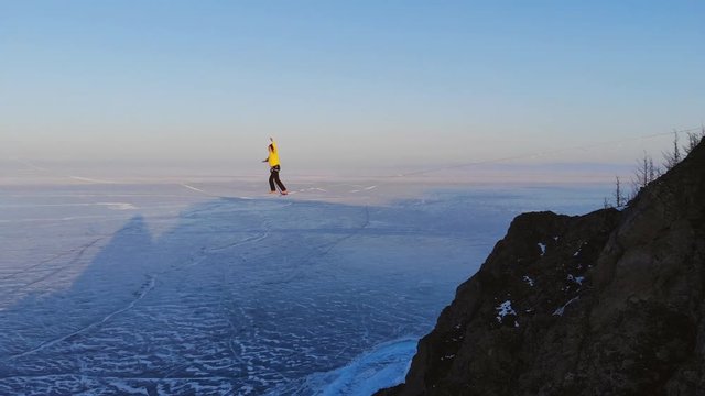 A young woman conquers the sling during slackline training high in the mountains.