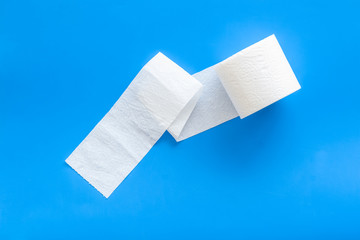 Toilet paper roll on blue background top view
