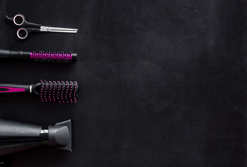 Hairdresser equipment for cutting hair and styling with combs, sciccors, brushes on black background top view copyspace