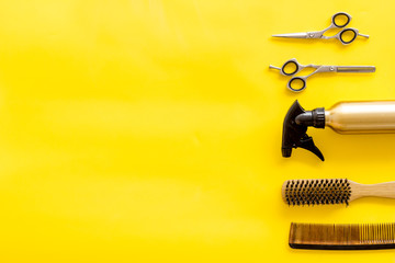 Hairdresser equipment for cutting hair and styling with combs, sciccors, brushes on yellow background top view copyspace