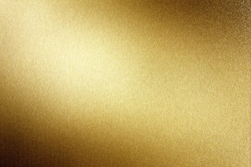 Light shining on brushed gold metal plate, abstract texture background