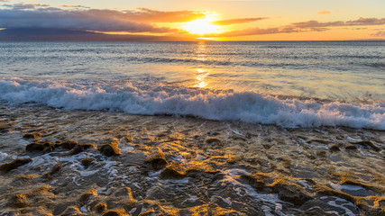 Naklejka premium Ocean Sunset - Colorful sunset view of strong waves rushing into a rocky beach at north-west coast of Maui island, Hawaii, USA.