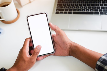 Cropped shot view of man hands holding smart phone with blank copy space screen for your text message or information content, female reading text message on cell telephone during in urban setting. 