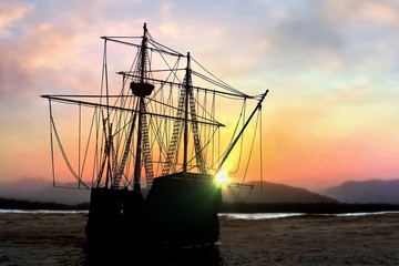 Pirate ship sailboat at the open sea during  sunset