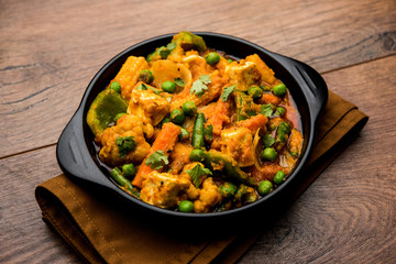 Mix vegetable curry - Indian main course recipe contains Carrots, cauliflower, green peas and beans, baby corn, capsicum and paneer/cottage cheese with traditional masala and curry, selective focus