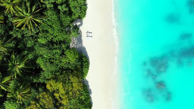 aerial drone overhead shot over the Jamaica island with white sand beach and two sunbeds, ideal tropical honeymoon destination