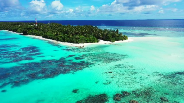 dolly out shot, Flight over a palm tree beach and clear blue water with corals of Saona, Dominican Republic