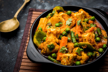 Mix vegetable curry - Indian main course recipe contains Carrots, cauliflower, green peas and beans, baby corn, capsicum and paneer/cottage cheese with traditional masala and curry, selective focus - obrazy, fototapety, plakaty