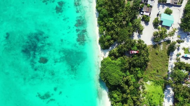 aerial drone establishing shot of tropical island with luxury resorts, white sand beach and crystal clear water of Philippine sea